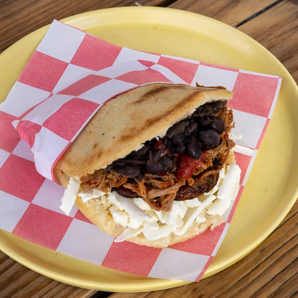 A Venezuelan La Latina arepa filled with shredded beef, black beans, plantains, and white cheese.